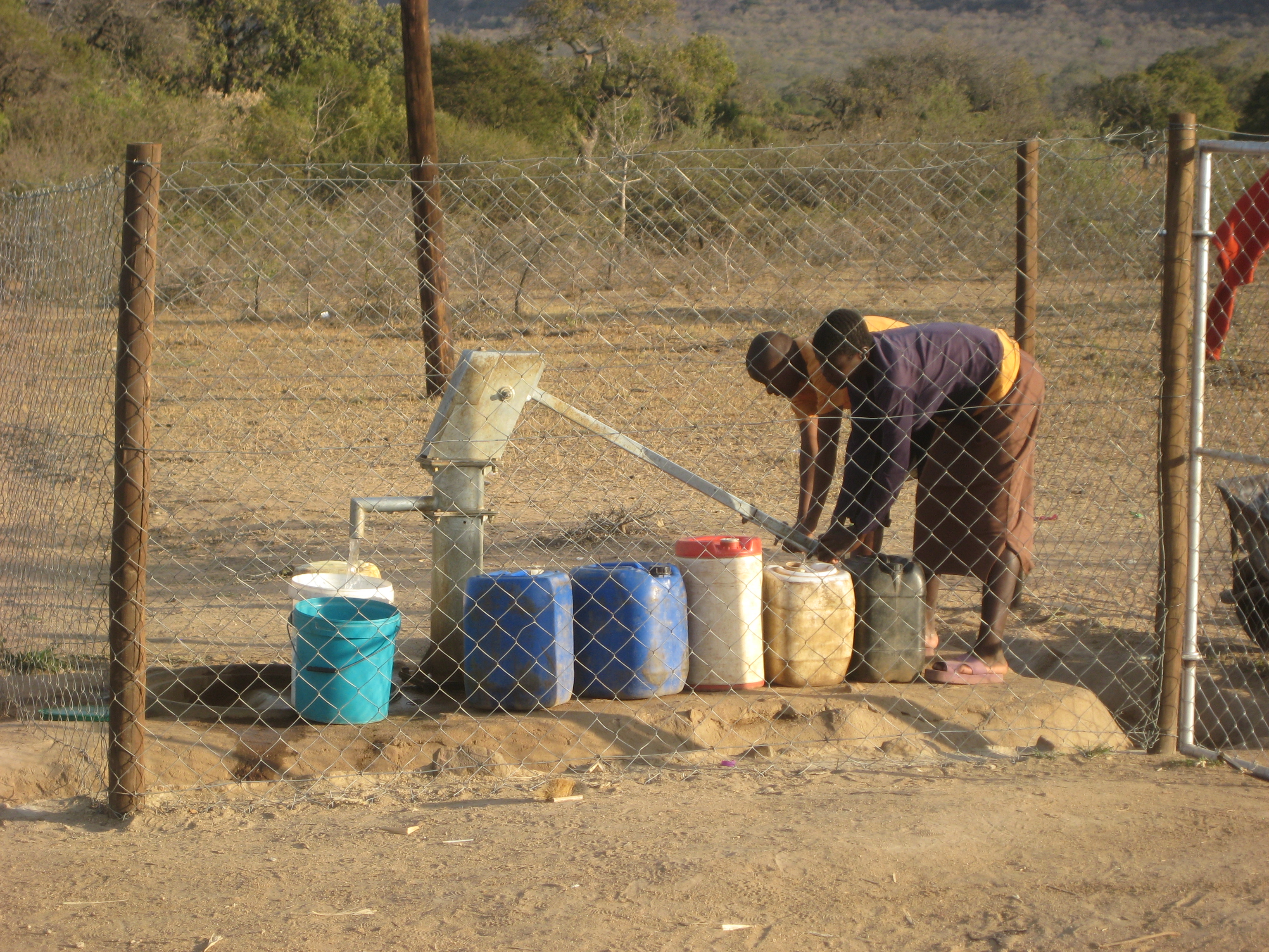 Girls fetching water using a handpump.